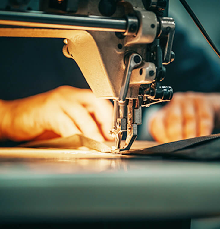画像:職人がミシンでスーツを縫製しているイメージ